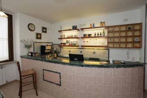 een bar in een restaurant met een klok aan de muur bij Il Cavallino in Fossombrone