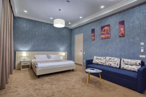 a bedroom with a bed and a blue wall at Benefit Boutique Hotel in Odesa
