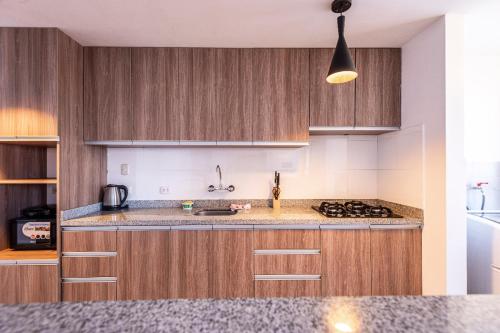 a kitchen with wooden cabinets and a counter top at El Triunfo Apartments in Cusco