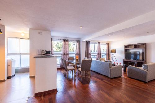 a large living room with a table and chairs at El Triunfo Apartments in Cusco