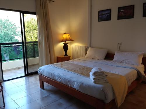 a bedroom with a bed with a lamp and a window at Master's Hotel - Ehden in Ehden