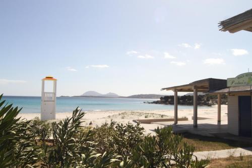 a building on a beach with the ocean in the background at Smeralda in Cugnana