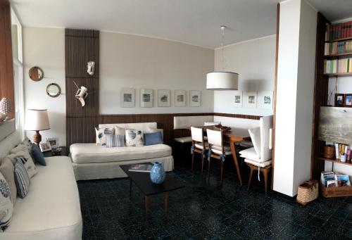uma sala de estar com um sofá e uma mesa em LIGURIA HOLIDAYS - Sulla scogliera con spiaggia privata em Sori
