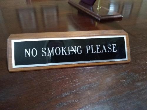 a sign that says no smoking please on a wooden floor at Southern Comfort Suites in Mayfield