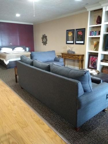 a living room with a couch and a bed at Southern Comfort Suites in Mayfield