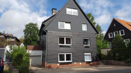 une maison noire avec des fenêtres blanches sur une rue dans l'établissement Wanderglück, à Braunlage