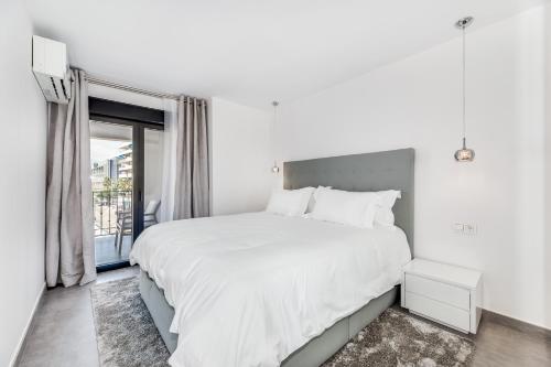 Un dormitorio blanco con una cama grande y una ventana en by RIVA - Luxurious, Exclusive 2 Bedroom Apt inside Puerto Banus, en Marbella