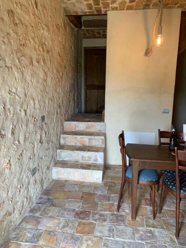 a room with a table and chairs and stairs at Charme in Perillis in Popoli