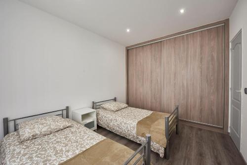 1 dormitorio con 2 camas y puerta corredera en Appartement T3 Rdc au calme, 6 couchages, en Le Pin