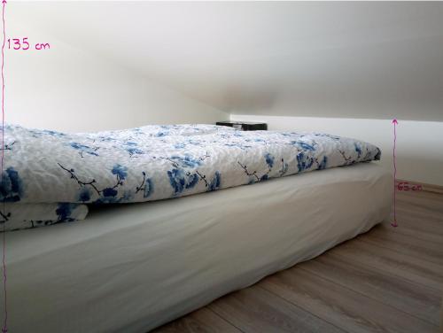 a bed with a blue and white comforter on it at Vatnsás 10 in Stykkishólmur