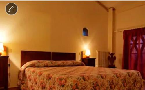 a bedroom with a bed with a red bedspread at Agriturismo La Moraia in Poggibonsi