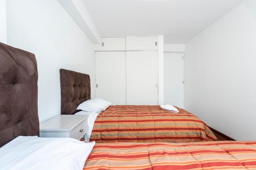 a bedroom with a bed and a white cabinet at El Triunfo Apartments in Cusco