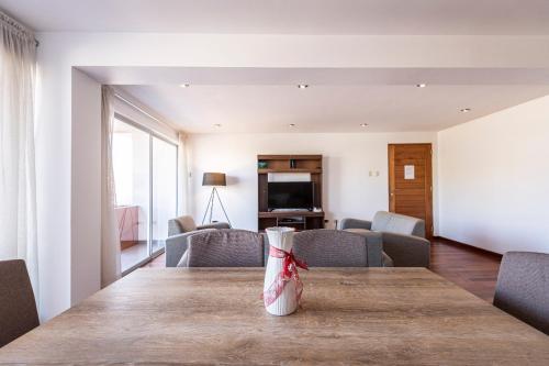 a table with a vase on it in a living room at El Triunfo Apartments in Cusco