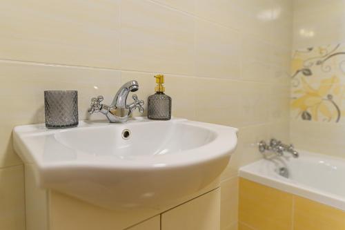 a bathroom with a white sink and a bath tub at Penzion Florián Telč in Telč