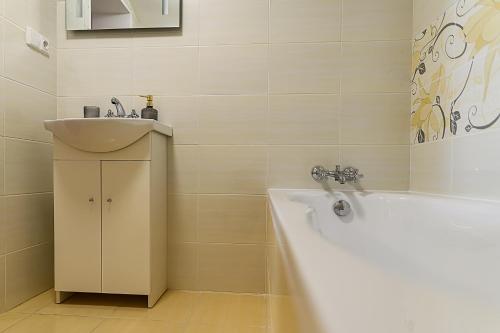 a bathroom with a sink and a bath tub next to a sink at Penzion Florián Telč in Telč