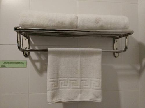 un toallero con toallas blancas en el baño en Puteri Bay Hotel, en Melaka