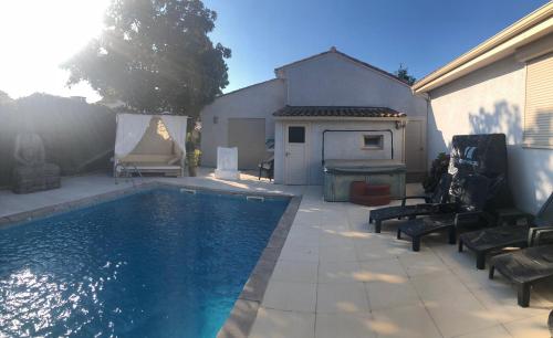 une piscine dans une cour avec des chaises et une maison dans l'établissement Villa Piscine indépendante sans vis à vis ET un studio sans accès piscine 2 possibilités au choix avec wifi, à Mudaison