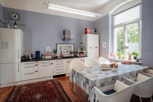a kitchen with a table and white cabinets and a window at Casa Hostel Pirna in Pirna
