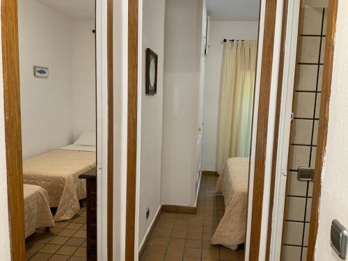Habitación pequeña con 2 camas y pasillo en Apartamento La Palmera Plaza, en Sant Martí d’Empúries