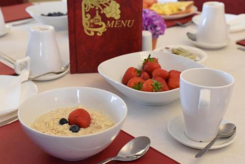 a table with bowls of cereal and bowls of strawberries at Rockfield Manor B&B, Knock in Knock