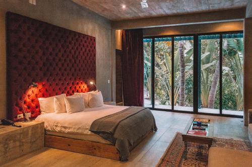 a bedroom with a large bed and a large window at Casa Malca in Tulum