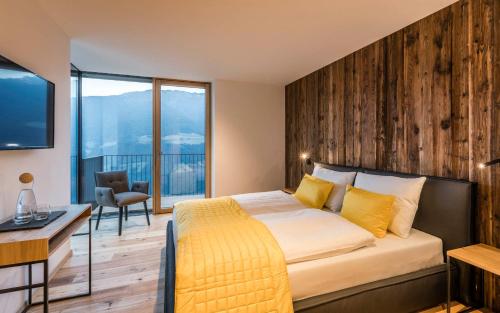 1 dormitorio con 1 cama grande y pared de madera en Chalet en Naturno