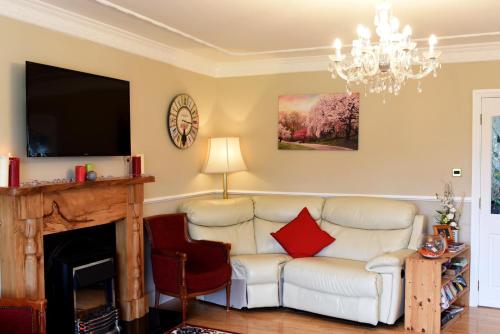 a living room with a couch and a fireplace at Rockfield Manor B&B, Knock in Knock