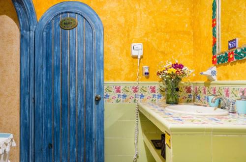 a blue door in a bathroom with a sink at Hacienda Boutique B&B and Spa Solo Adultos in Cozumel