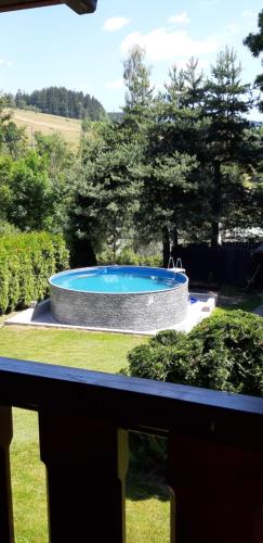 Una gran piscina en un patio con árboles. en Ubytování Monika, en Paseky nad Jizerou