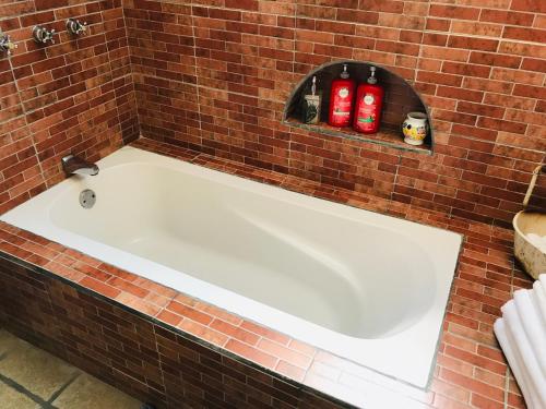 a white bath tub in a brick wall at Hacienda Boutique B&B and Spa Solo Adultos in Cozumel