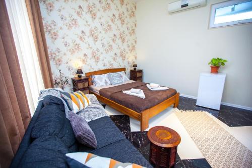 a living room with a bed and a couch at Shiny Avlabari Apartment in Tbilisi City