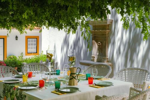 a table with a white table cloth and chairs and a fountain at Casa da Azenha in Peso da Régua