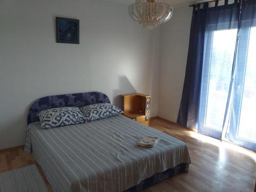 a bedroom with a bed and a television and a window at Apartment Darinka in Šibenik