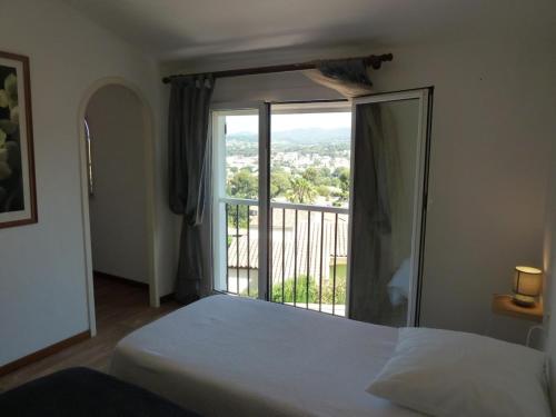 une chambre avec un lit et une grande fenêtre dans l'établissement Villa avec grande piscine plage et port de Sanary à pieds, à Six-Fours-les-Plages