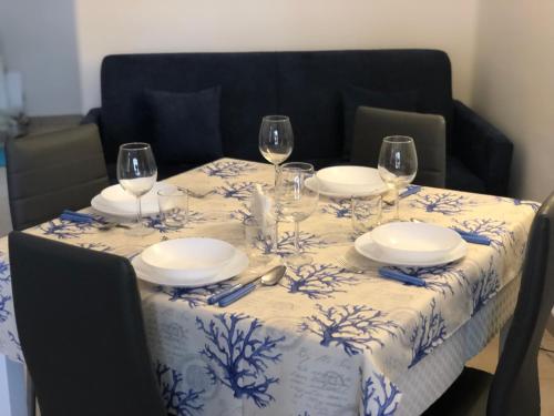 a table with plates and wine glasses on it at Xenia House in Lascari