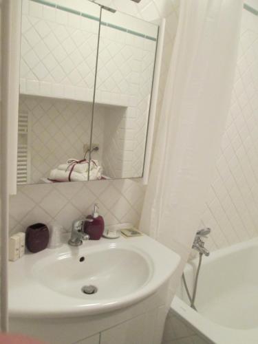 a white bathroom with a sink and a mirror at La Dolce Casetta in Grottaferrata