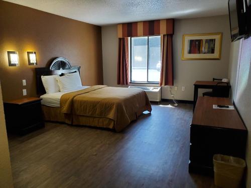 a hotel room with a bed and a window at Araamda Inn in Norcross