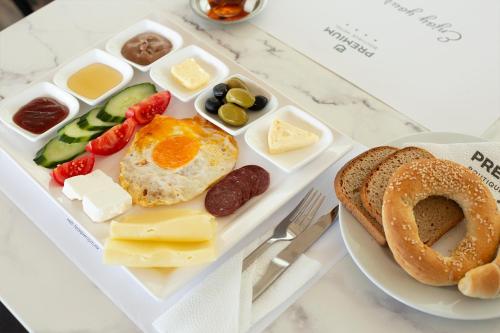 a tray of breakfast food with eggs cheese and bread at Hotel Premium in Skopje