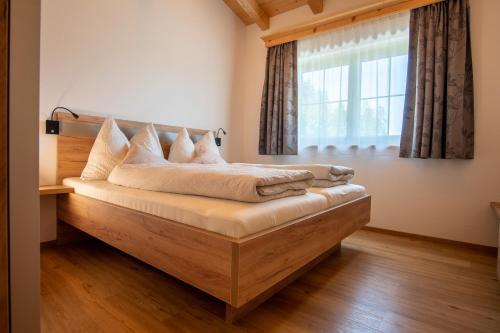 Cama en habitación con ventana en Hof Zenzern en Kitzbühel