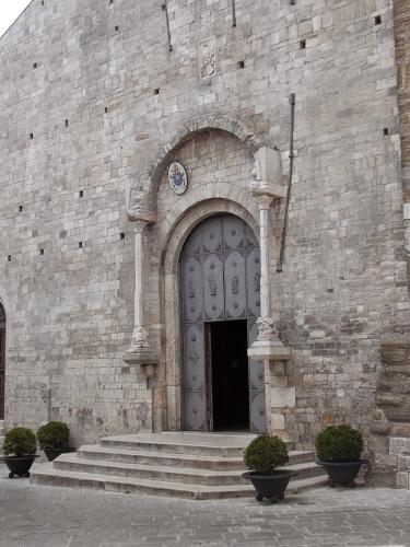 a stone building with a large door and stairs at Antica Dimora del Drengot in Acerenza