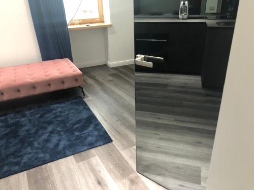 a living room with a red stool and a blue rug at Modern and Luxury Apartment in the Center of Kaunas in Kaunas