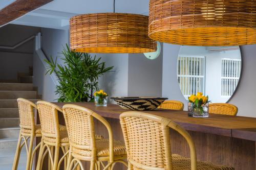 a dining room with wicker chairs and wicker lights at Casa La Merced by Mustique in Cartagena de Indias