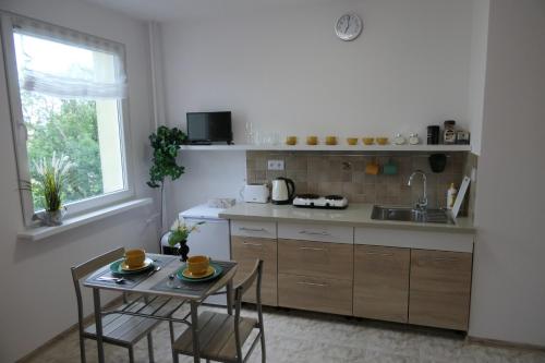 a kitchen with a table and chairs and a sink at Ares Apartments in Przemyśl