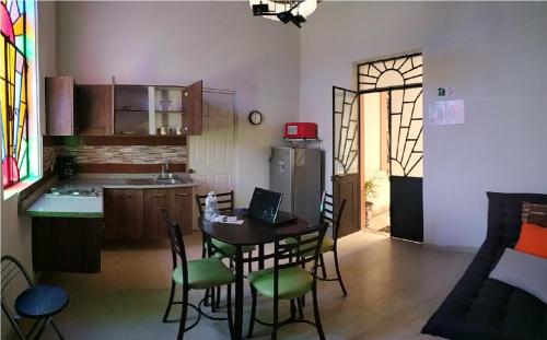 a kitchen with a table with chairs and a laptop on it at HOTEL DEL CAPITAN DE PUEBLA, DEPARTAMENTOS in Puebla