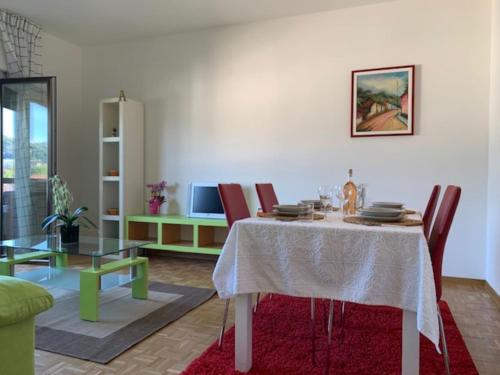 ein Esszimmer mit einem Tisch mit Stühlen und einem Tisch in der Unterkunft Karl&Deby Lugano stazione/centro in Lugano