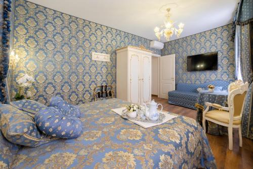 a bedroom with blue walls and a bed with a table at Canal View San Marco Luxury Rooms in Venice