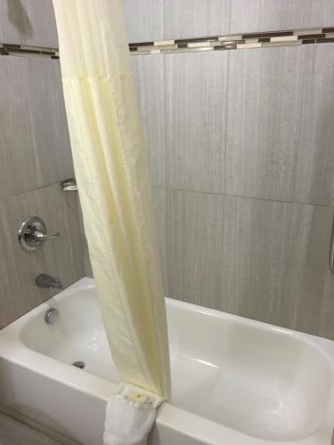 a bathroom with a white tub and a shower curtain at Comfort Inn & Suites, White Settlement-Fort Worth West, TX in Fort Worth