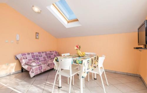 a living room with a table and chairs and a couch at MILKA APARTMANI POVLJANA in Povljana