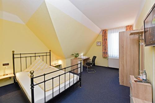Schlafzimmer mit einem Bett, einem Schreibtisch und einem Fenster in der Unterkunft Hotel Haus Kleimann-Reuer in Gladbeck