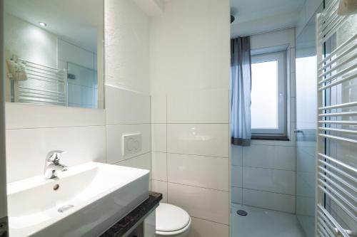 Un baño blanco con lavabo e inodoro. en dat geele hus Nr. 3, en Büsum